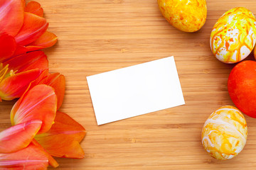 Easter eggs with tulips on wooden board, easter holiday concept. Copyspace for text