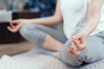 A Woman Over the Age of 50 is Doing Yoga at Home.