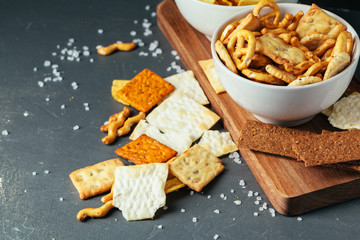 Beer snacks on stone table. Various crackers, potato chips. Top view