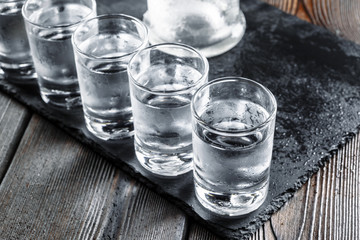 Vodka in shot glasses on rustic wood background