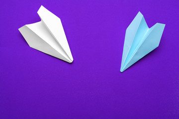 white paper airplane on a purple background