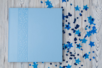 blue photo book with  leather cover.  stylish wedding photo album with space for text.  Beautiful photobook on a wooden background.
