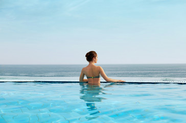 Woman enjoying relaxation in pool and looking