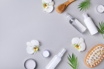 Fototapeta na wymiar Spa, beauty treatment and wellness background with massage brush, orchid flowers and cosmetic products. Top view and flat lay.
