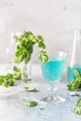 Colorful refreshing summer drink with basil seeds on light background.