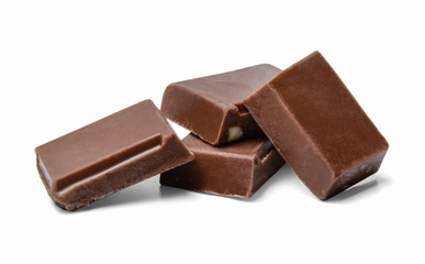 Small chocolate bars in a chaotic mess on a white isolated background. Side view. Close distance.