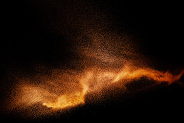 Fototapeta na wymiar Golden sand explosion isolated on black background. Abstract sand cloud.