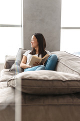 Fototapeta premium Smiling asian woman reading