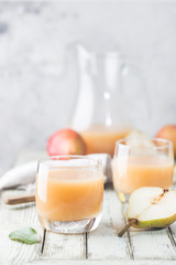 Fresh Pear Juice in a glasses with fresh fruits on light background