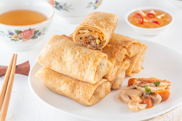 Traditional Chinese tortillas filled - bings in a plate on a white background, salads, Dam Sam snacks and cup of tea.