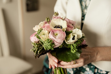 Braut h&auml;lt Brautstrauss mit Ranunkeln