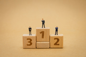Miniature people businessmen standing on Submitting on the podium award. using as background...