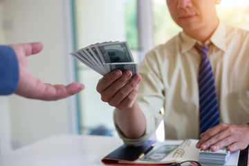 Two businessmen are receiving money to invest in future projects.concept