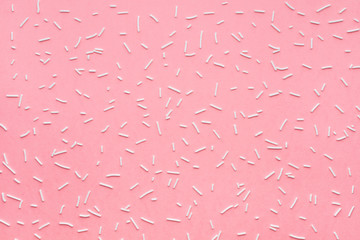 trendy pattern of white sprinkles over pink background, sugar sprinkle dots