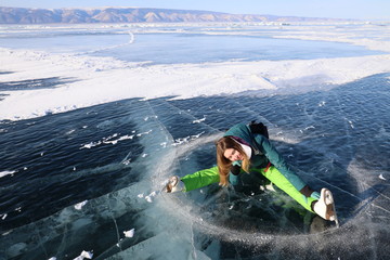 Naklejka premium Girl with skates lying on ice of Baikal lake