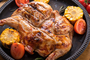 Roasted chicken garnish with corn and tomatoes. Closeup