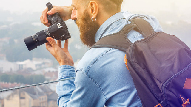 Traveler Young Man with a Beard Photographs Attractions and Panorama of the Ancient City from a High Observation Platform. Travel Tourism Concept