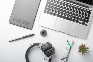 Desktop designer and creative retoucher with a graphics tablet, laptop, glasses. Design, flat lay