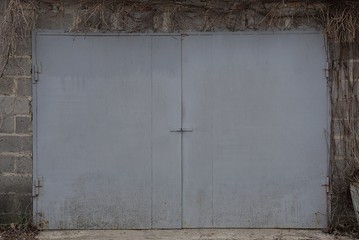 facade of a gray brick garage with iron gates closed
