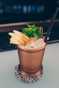 Golden metal vase exotic healthy Cocktail drink with burning cinnamon and lime, mint beverage on a bar counter. Selective focus. Top view. Trendy stylish edit. Copy paste space design service barman
