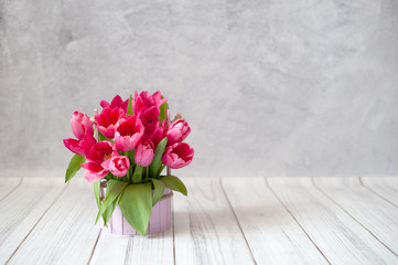 A bouquet of tulips on a gray concrete background with copyspace