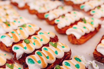 Eat sweet dessert cuisine Homemade Close-up french cake eclairs or profiteroles with custard Red Pink, chocolate and strawberries. Delicious menu item. Top view, flat lay in bakery  Pastry products