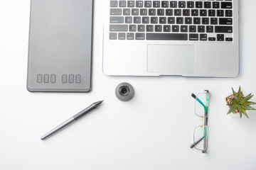 Top view of the workplace designer. Creative designer, graphics tablet, laptop, and accessories for the graphic designer.Flat lay.On a white background