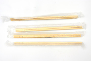 pair of chopsticks in plastic placed on  white background