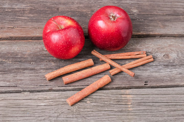 cinnamon sticks and apples on wooden background