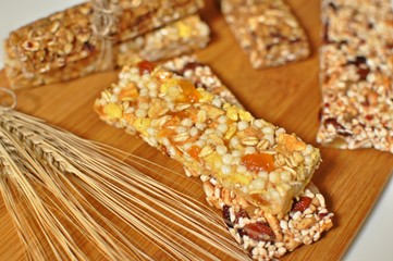 Bars of healthy cereal sweet snacks on wooden board. Top dish