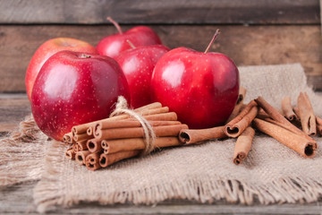 cinnamon sticks and apples on wooden background