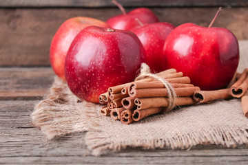 cinnamon sticks and apples on wooden background