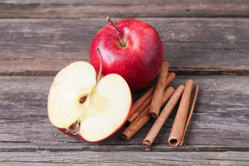 cinnamon sticks and apples on wooden background