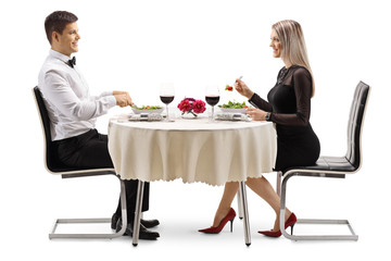 Young man and woman eating salad at a table
