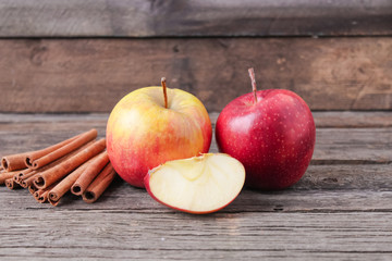 cinnamon sticks and apples on wooden background