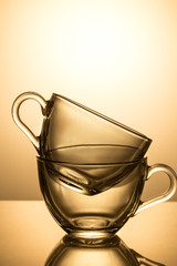 Set of two glass cups on a yellow background
