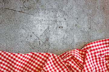 Fototapeta premium Culinary background. Dark stone surface and red towel in a white cage. copy space top view