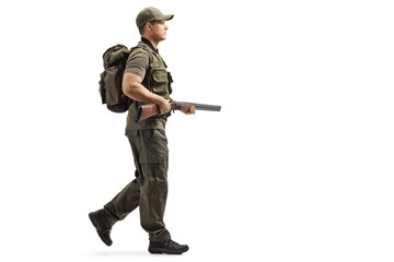 Hunter walking and holding a shotgun