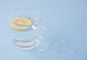 water with lemon on the blue table with crystal beads