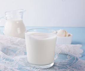 Yogurt in glass, milk and cream cheese on a table with white napkin.