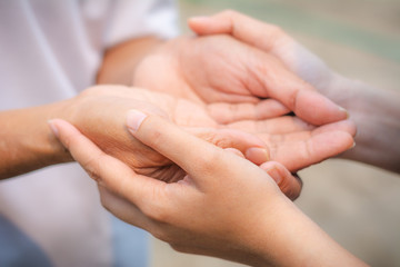 Asian senior and asian young holding hands.