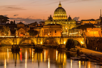 Naklejka na ściany i meble Sunset Tiber River - A colorful dusk view of Tiber river at Sant' Angelo Bridge, with the dome of St. Peter's Basilica towering in background, as seen from the Ponte Umberto bridge. Rome, Italy.