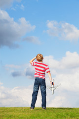 Boy holding model plane looking to the sky