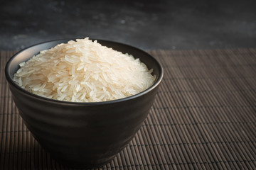 Obraz na płótnie Canvas Steamed rice in bowl on black background. Copy space.