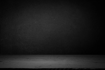 cement floor in dark room with spot light. black background.