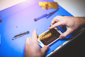 Man fixing broken mobile device.