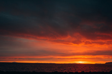 Sunset on the shore of the ocean. Red sunset