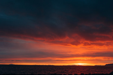 Naklejka na ściany i meble Sunset on the shore of the ocean. Red sunset
