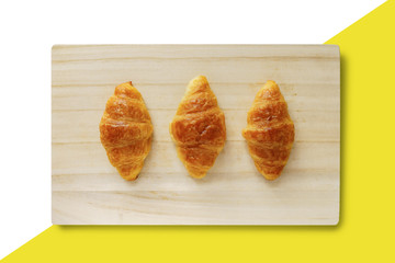 Croissant on a wooden tray