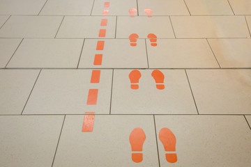 Gangführung mit orangen Füßen auf dem Fussboden